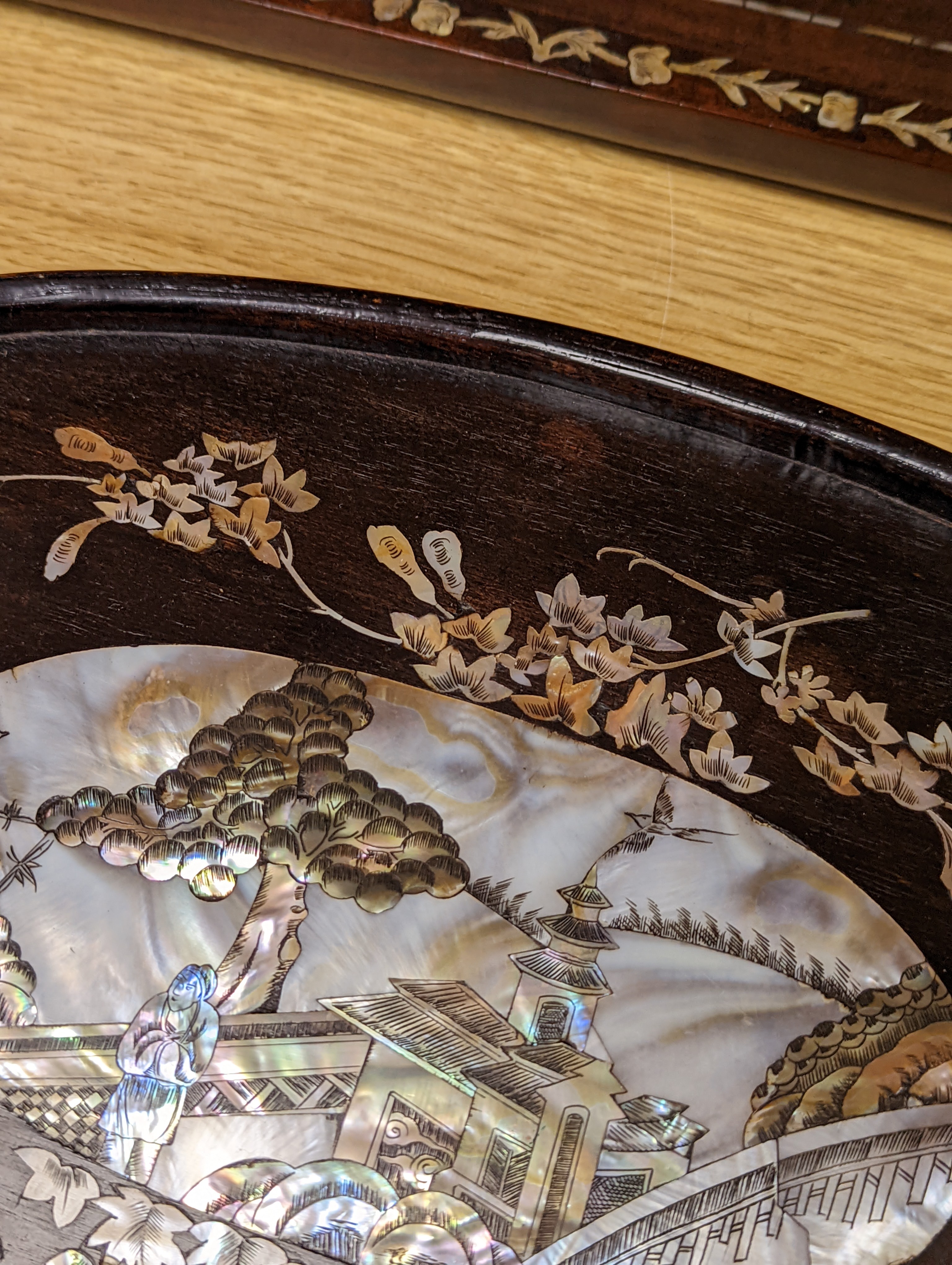Two Chinese mother of pearl inlaid hongmu trays, the rectangular example with birds and insects amid flowers and the smaller oval example with a pavilion in a landscape within floral sprays 55x34cm